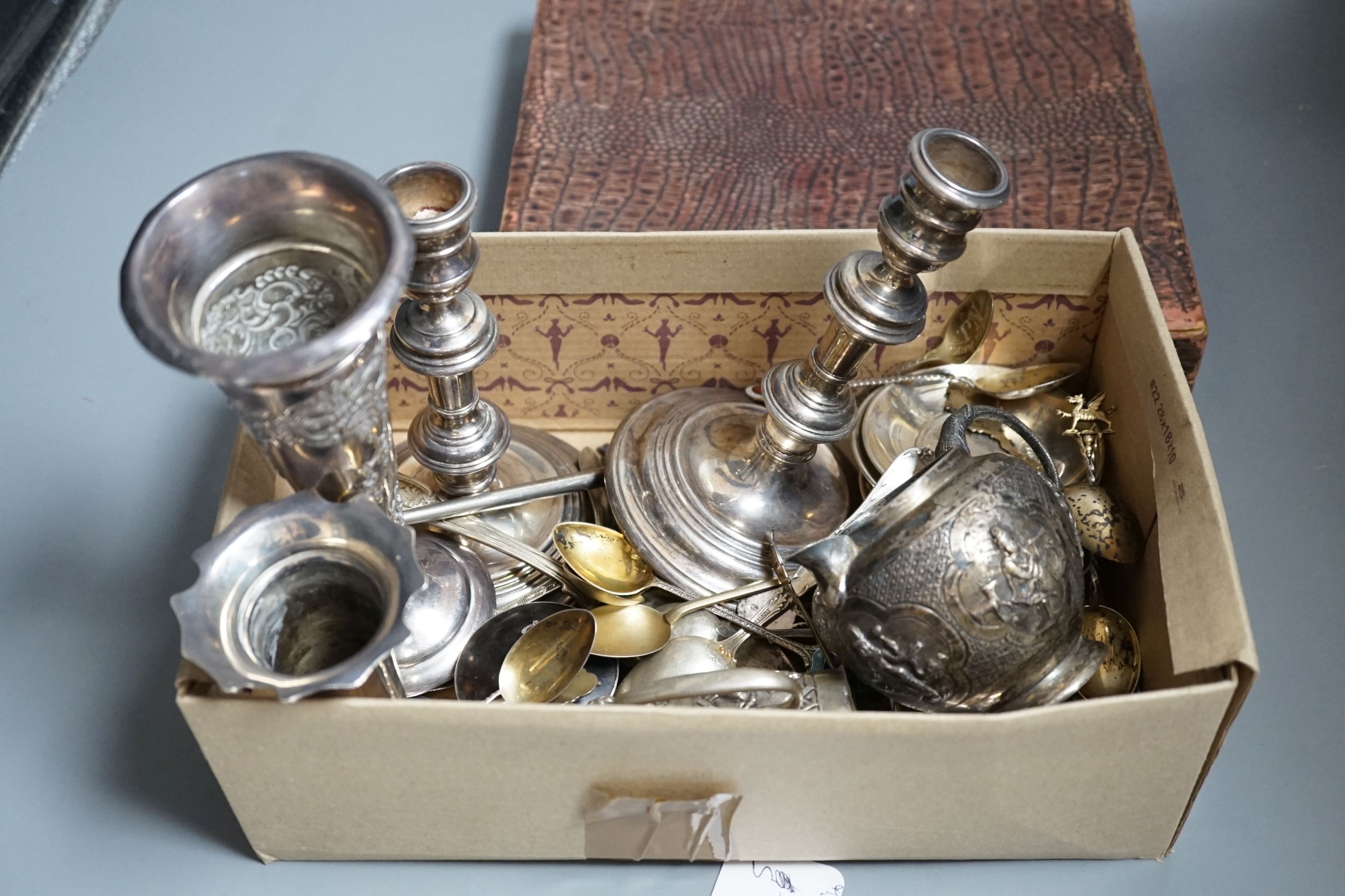 A pair of 1960's silver candlesticks, 19.2cm, weighted, a small silver vase, small silver and tortoiseshell pill box, two small silver armada dishes, two Indian white metal cream jugs, four 'coin' dishes, a quantity of a